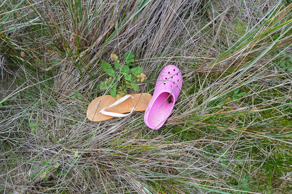 shoes-lying-in-grass-near-beach