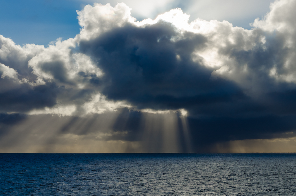 sun-ray-through-clouds-over-ocean